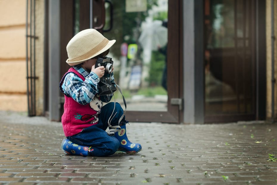 a child taking a picture using vintage camera