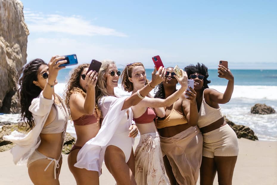 agroup of women taking photos with cellphones