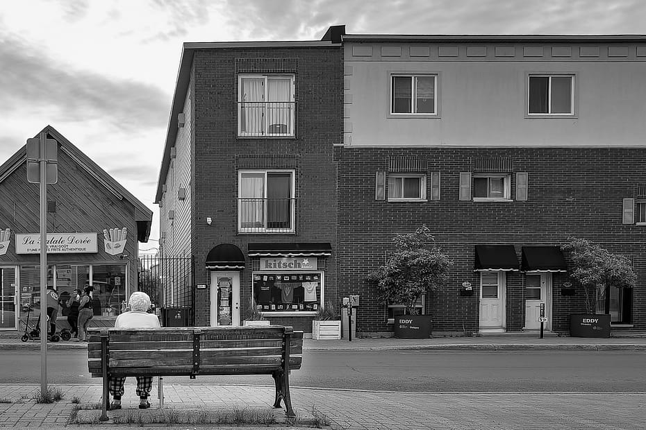 black and white photo of woman sitting on a bench